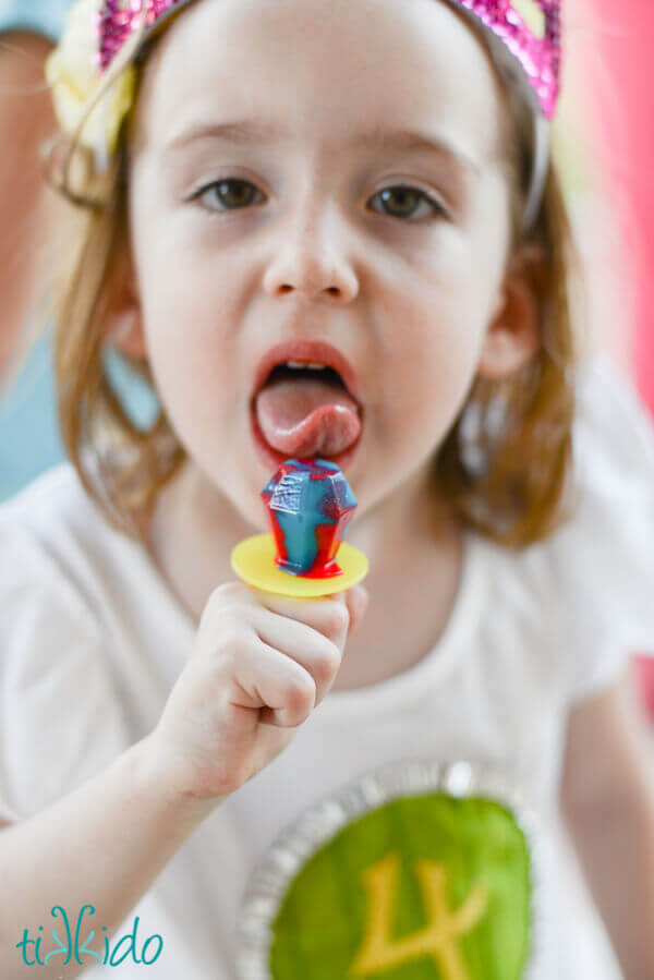 Little girl licking a ring pop that came out of a Smaug the Dragon piñata at the Hobbit birthday party.