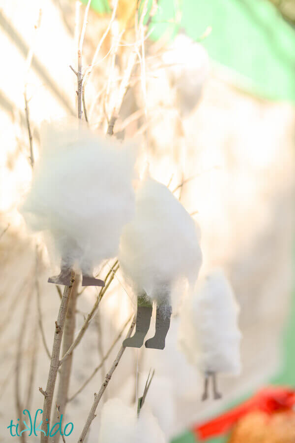 Cotton candy that looks like dwarves wrapped in spider silk, hanging from tree branches on the Lord of the Rings birthday party dessert table.