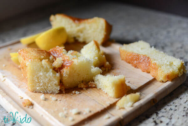 Lemon quick bread crumbled on a wooden cutting board.