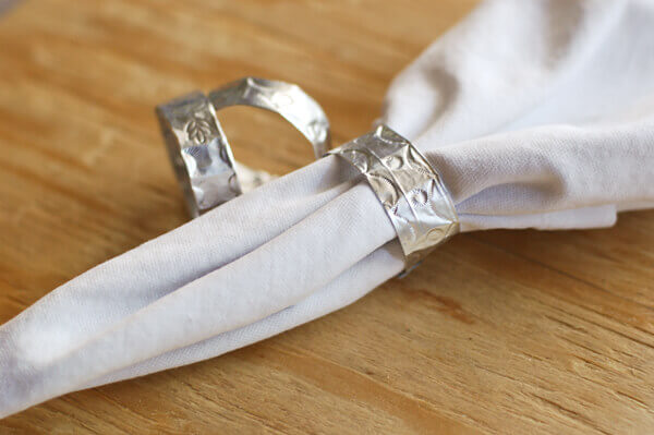 Mexican Punched Tin Napkin Rings, one containing a white napkin.