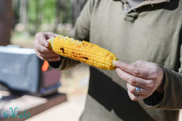 Campfire grilled ear of corn being eaten