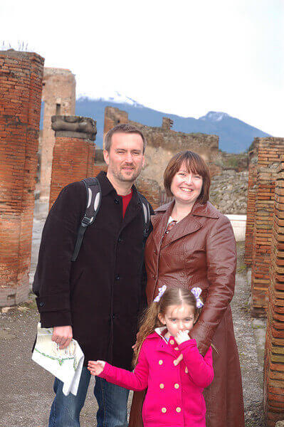 A man, a woman, and a little girl standing in the ruins of Pompeii