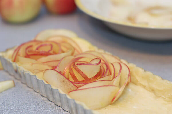 Thin slices of apples being shaped into roses for the rose apple pie.