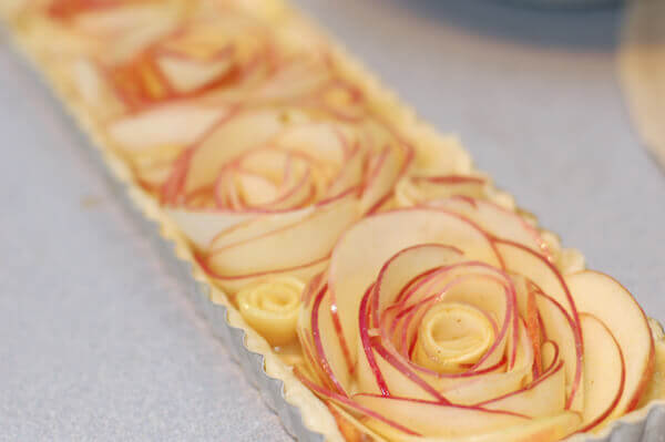 Thin slices of apples being shaped into roses for the rose apple pie.