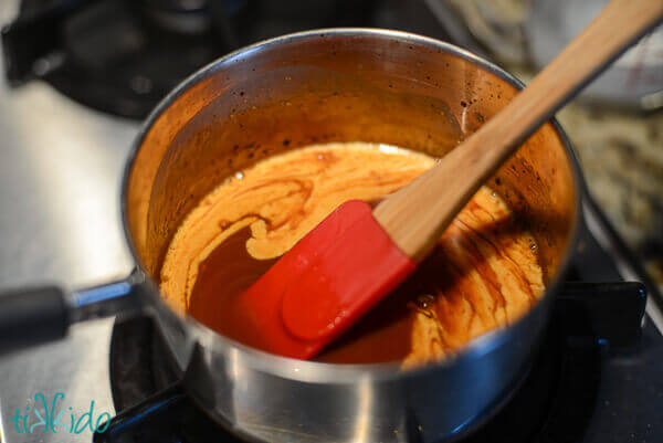 Caramelized sugar with cream being swirled to make salted caramel for salted caramel buttercream.