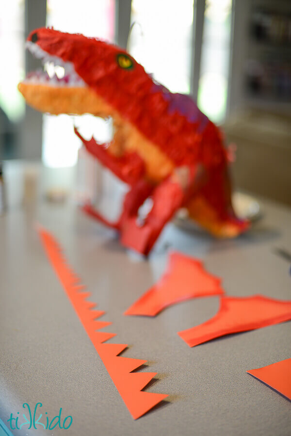 Wings and spiked ridge embellishments being made out of paper to make the DIY Dragon piñata.