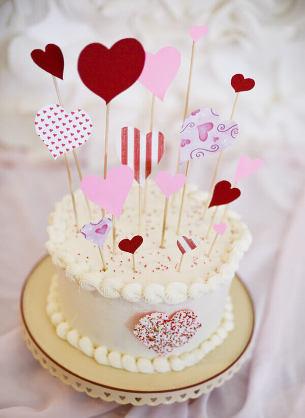 Strawberry cake with heart cake toppers to make a Valentine's day cake.
