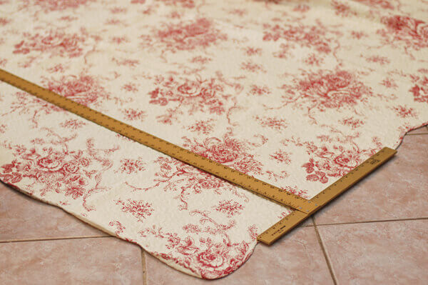 Large measuring square on an inexpensive red and white quilt.