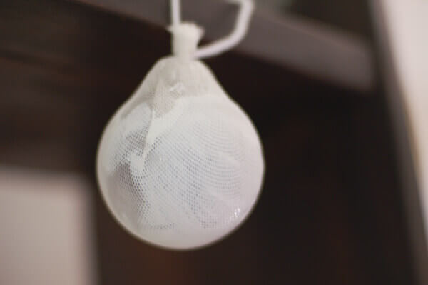 Wedding Veil Keepsake Christmas Ornament being made by covering an ornament ball with silk tulle.
