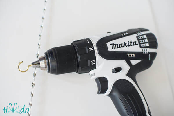 Makita drill with mounted hook screw and twisted flat metal wire for Victorian tinsel ornaments.