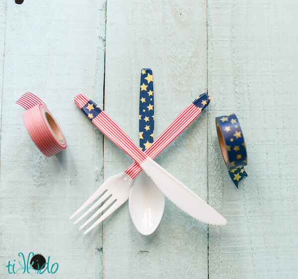 Plastic cutlery decorated with patriotic washi tape for a 4th of July party.