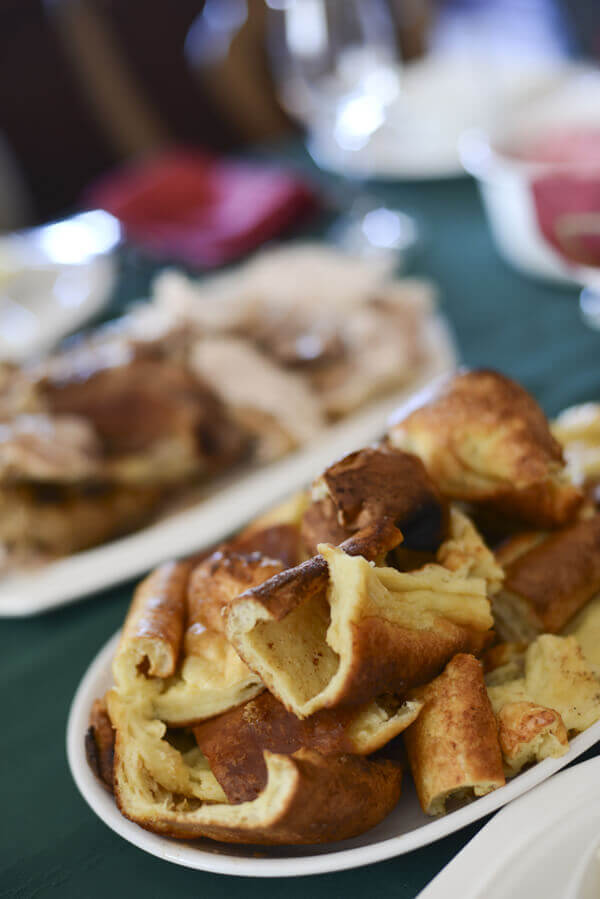 Plate towering with pieces of Yorkshire pudding on a Thanksgiving table.