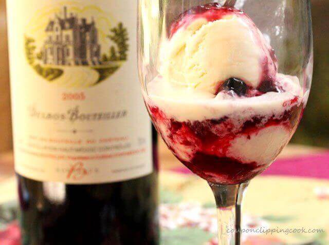 Berry red wine ice cream sauce over vanilla ice cream served in a wine glass.