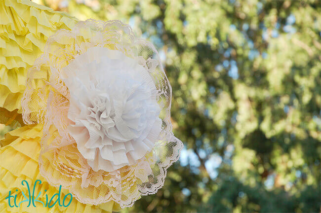 Crepe paper and lace flower embellishment on a decorated piñata.