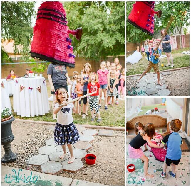 Little girl hitting a Dalek pinata at a Doctor Who birthday party.