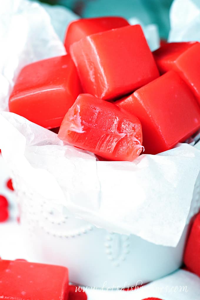 Red cinnamon caramels in a white dish.