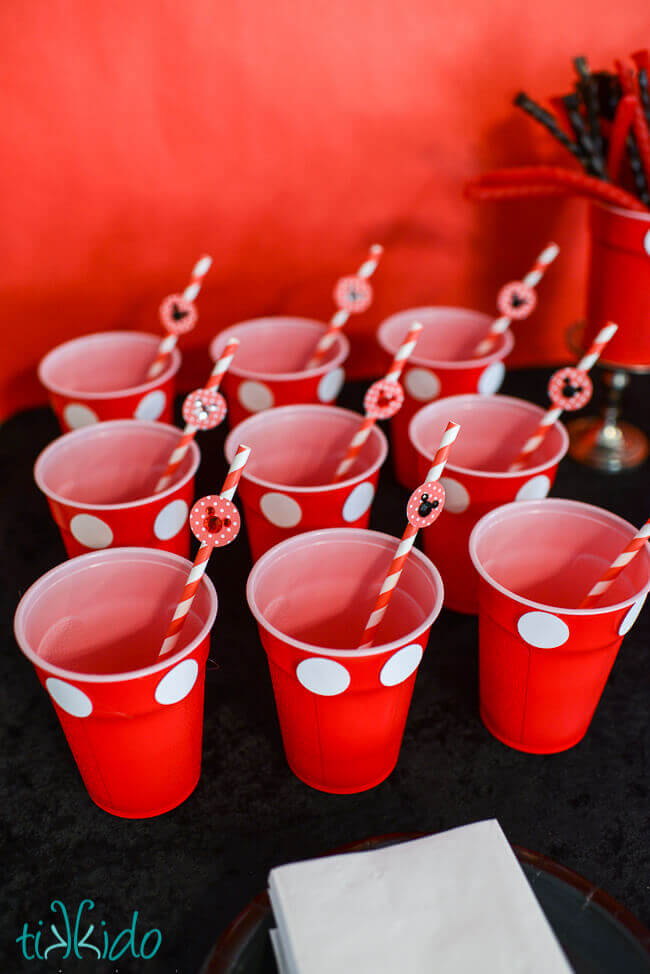 Mickey Mouse Straws set up in red plastic cups embellished to look like Mickey Mouse pants.