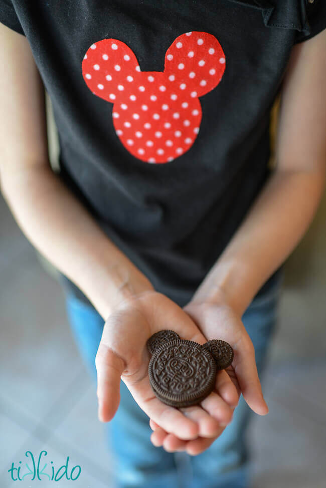 Little girl holding an easy Oreo Mickey Mouse Cookie in her hands.