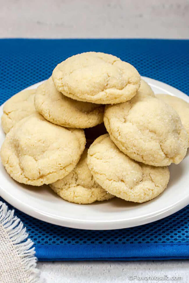 Eggless soft sugar cookies on a white plate on a blue background.