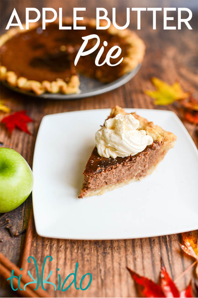 Slice of apple butter pie and the rest of the pie in its pie tin on a wooden table covered in fall leaves and fresh apples.  Text overlay reads "Apple Butter Pie."