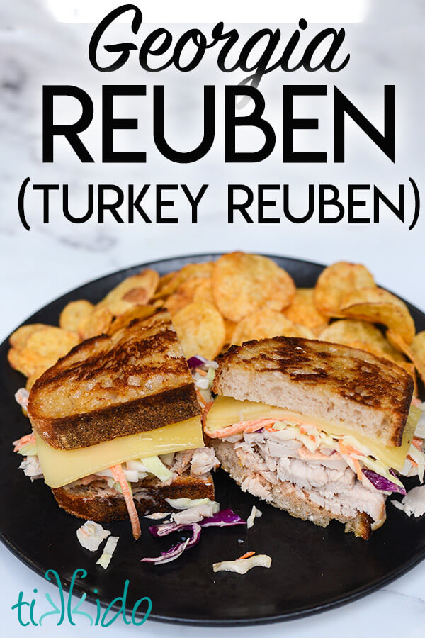 Turkey Reuben sandwich cut in half on a black plate, with chips piled behind the sandwich, and text overlay reading Georgia Reuben (Turkey Reuben)