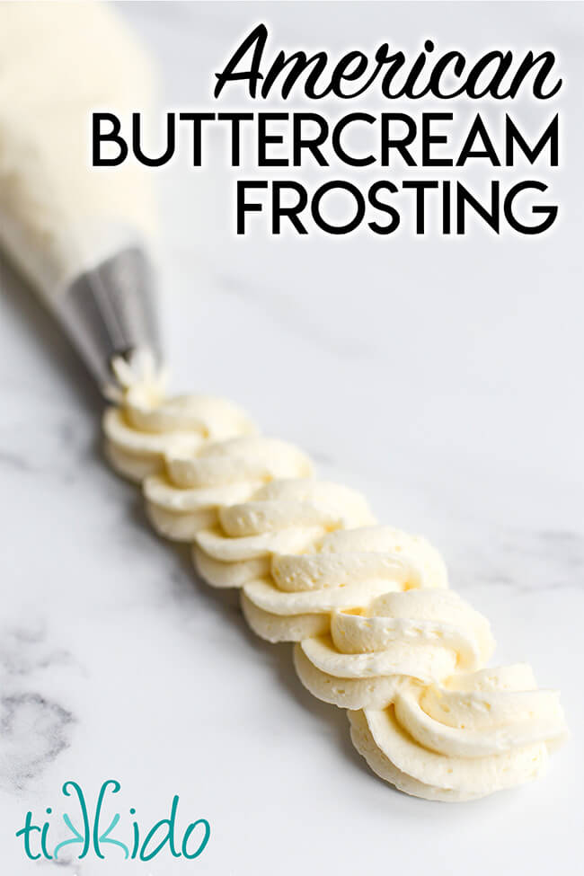 American buttercream frosting piped in a swirl on a white marble surface.