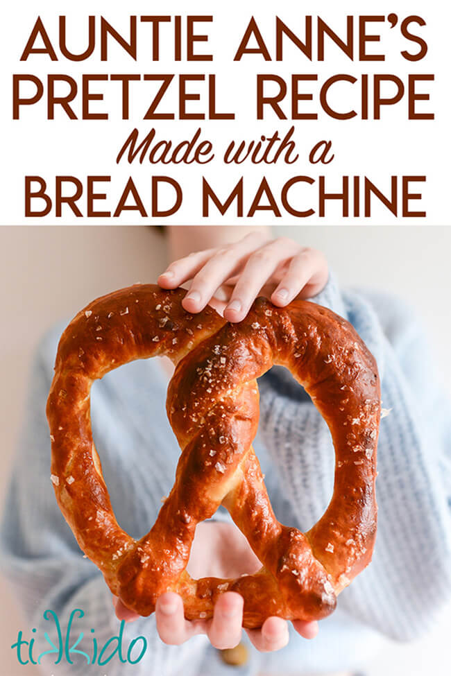 Large Auntie Anne's copycat pretzel held with two hands, with text overlay reading "Auntie Anne's Pretzel Recipe Made with a Bread Machine."