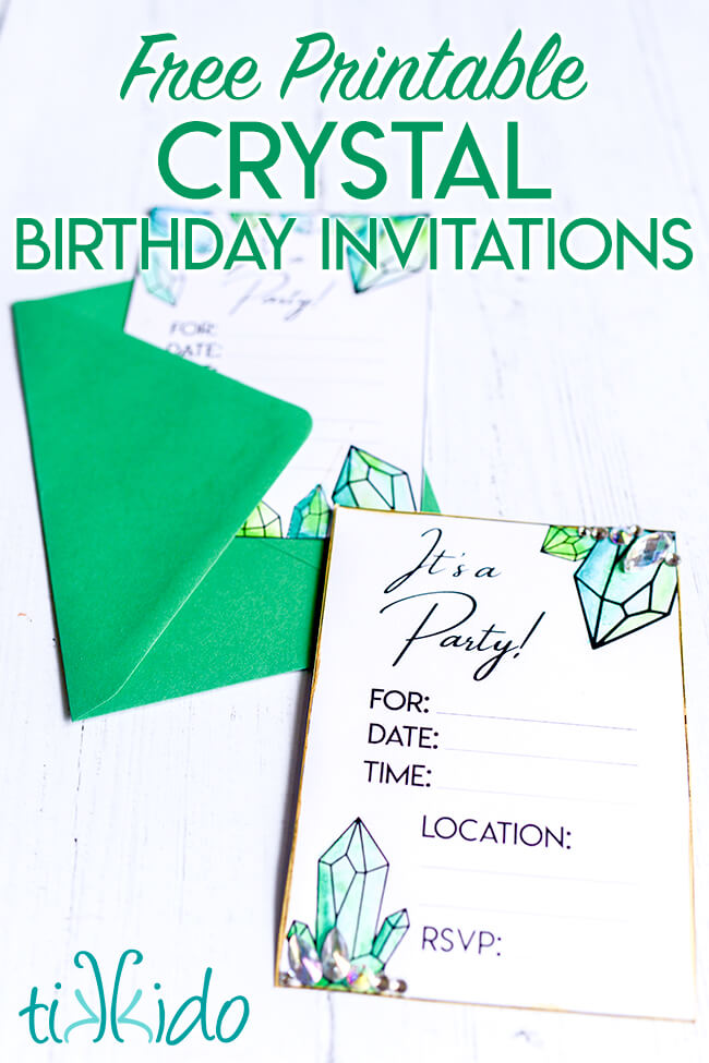 Two printable birthday party invitations, decorated with crystal drawings colored in with green watercolor paints.  The drawn crystals are embellished with Czech Preciosa rhinestones.  One of the invitations is tucked in an emerald green envelope.  Text overlay reads "Free Printable Crystal Birthday Invitations."
