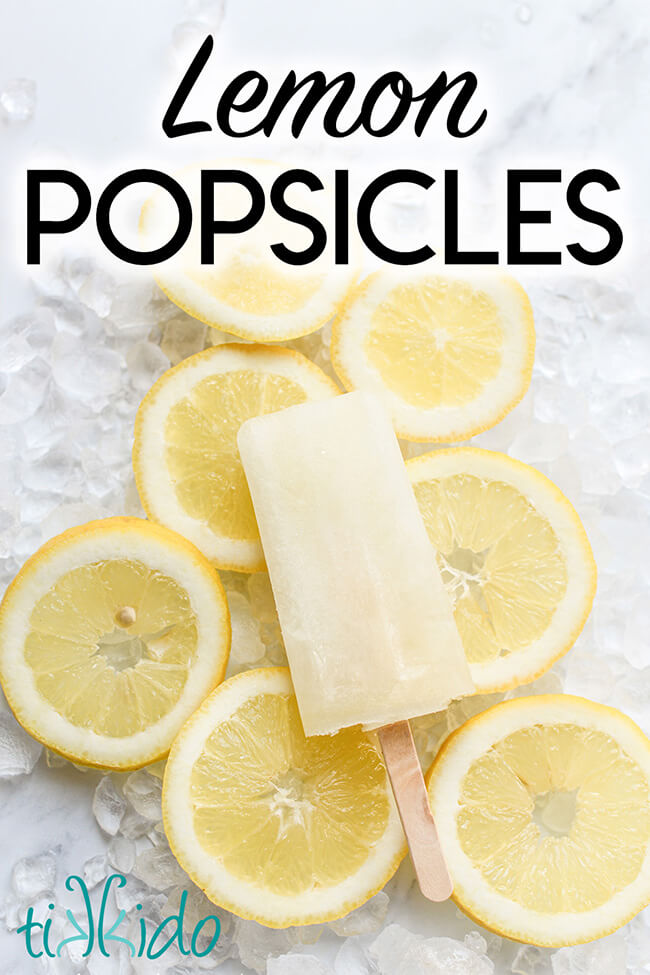 Lemonade popsicle resting on a bed of crushed ice and lemon slices, with text overlay reading "Lemon Popsicles."