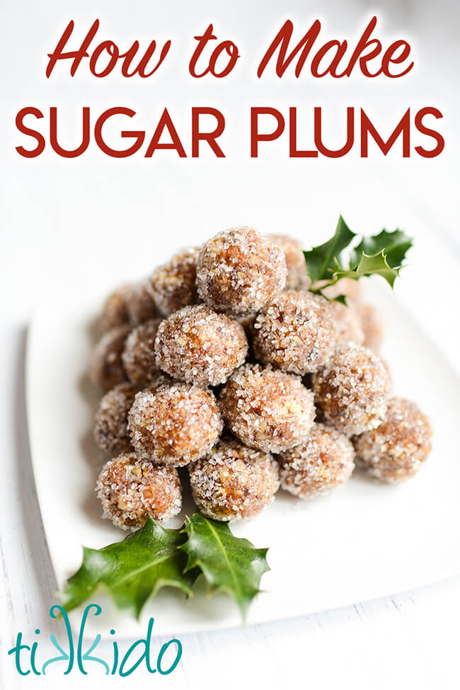 Sugar plums stacked in a pyramid on a white plate decorated with fresh holly leaves, with text overlay reading "How to Make Sugar Plums."