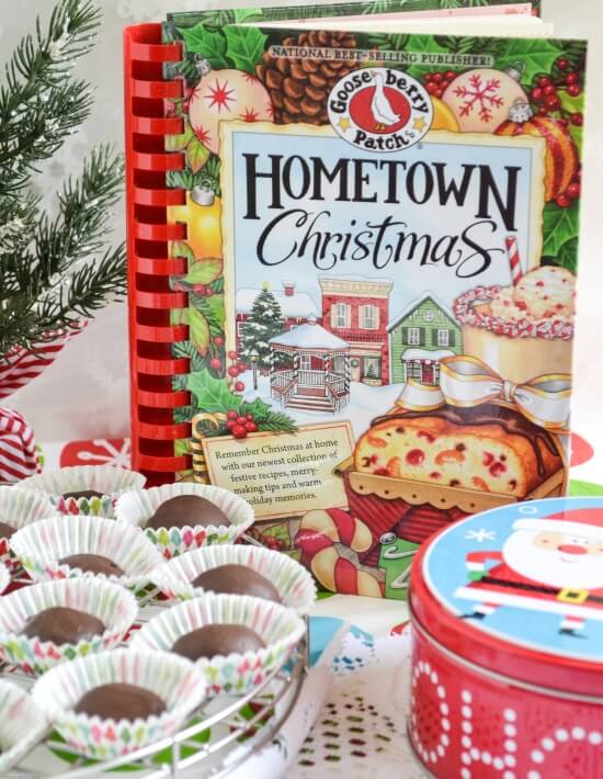 Tray of chocolate covered rasperry jellies candies in front of a Hometown Christmas Recipe Book.