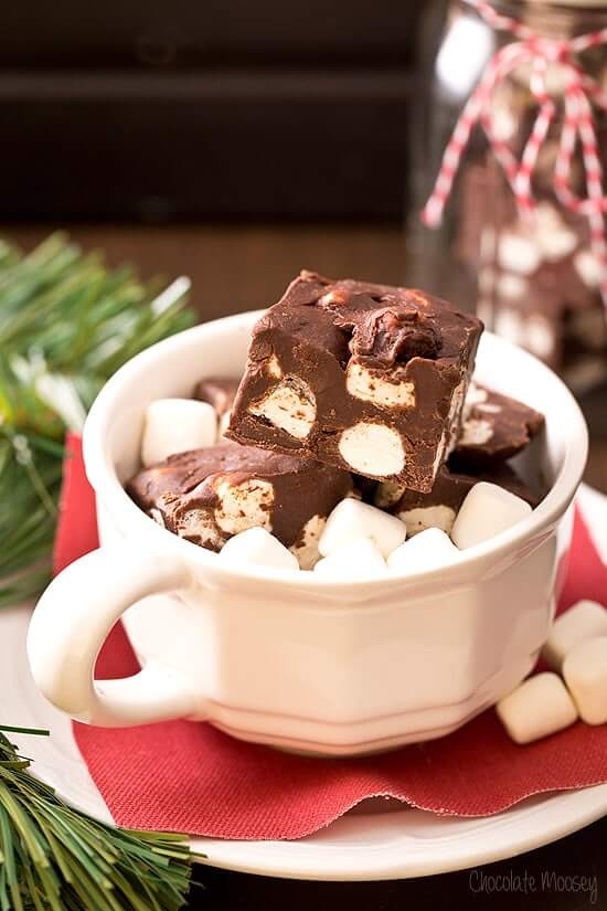 White mug filled with pieces of Hot Chocolate Fudge and mini marshmallows.