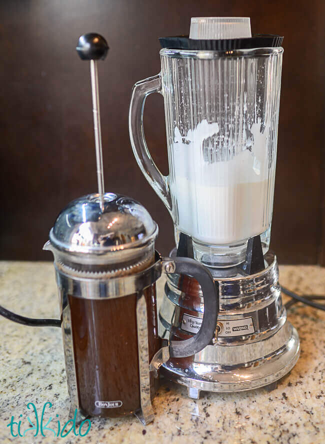 Coffee in a french press and whipped cream made in a blender for Irish coffee
