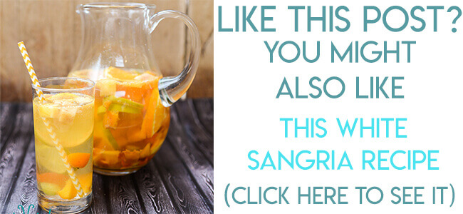 Summer White Sangria in a pitcher, with a glass of white sangria slightly in front of it, against a wooden backdrop
