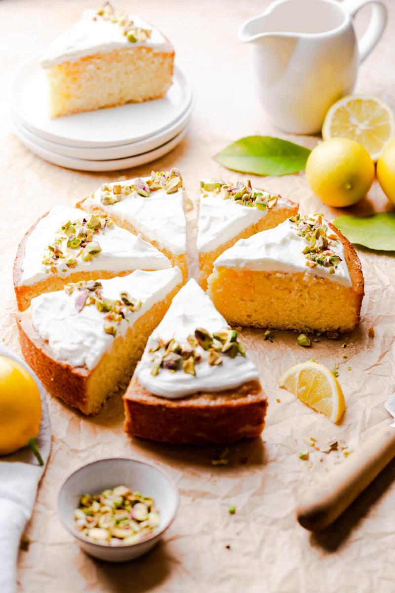 Lemon semolina cake cut into slices, topped with Greek yogurt and crushed pistachios.