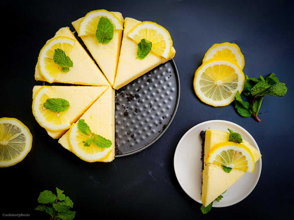 No bake lemon chiffon pie on a serving plate, sliced, next to a plate with a single slice of the lemon pie.