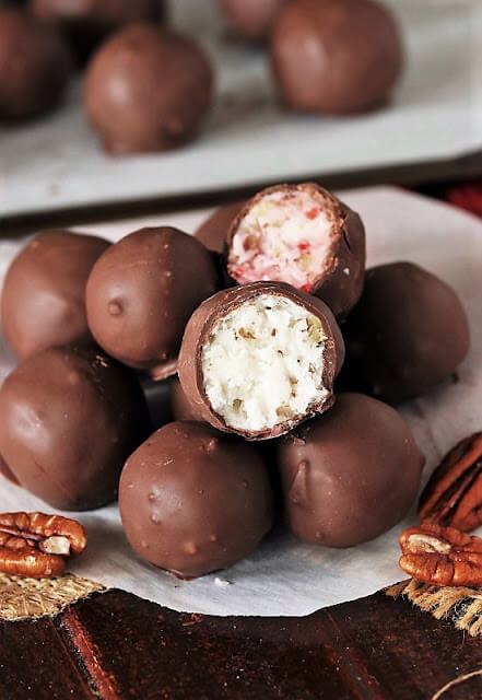 Martha Washington candies stacked on a circle of white paper, two of the candies cut in half so you can see the center of the candy.