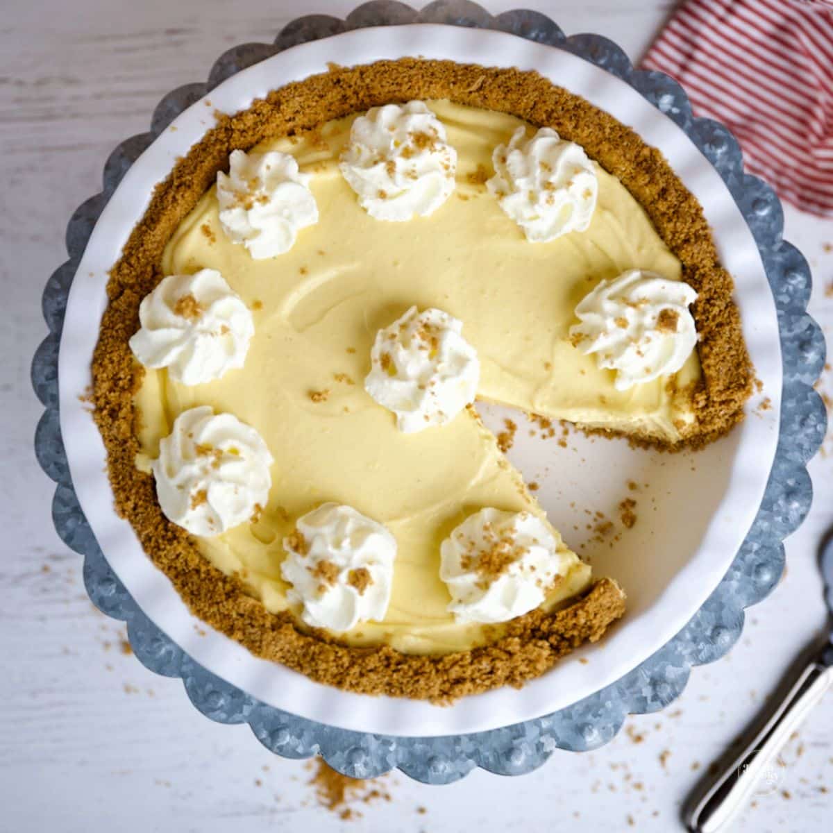 No bake eggnog pie in a white pie dish, with one slice of the pie missing.