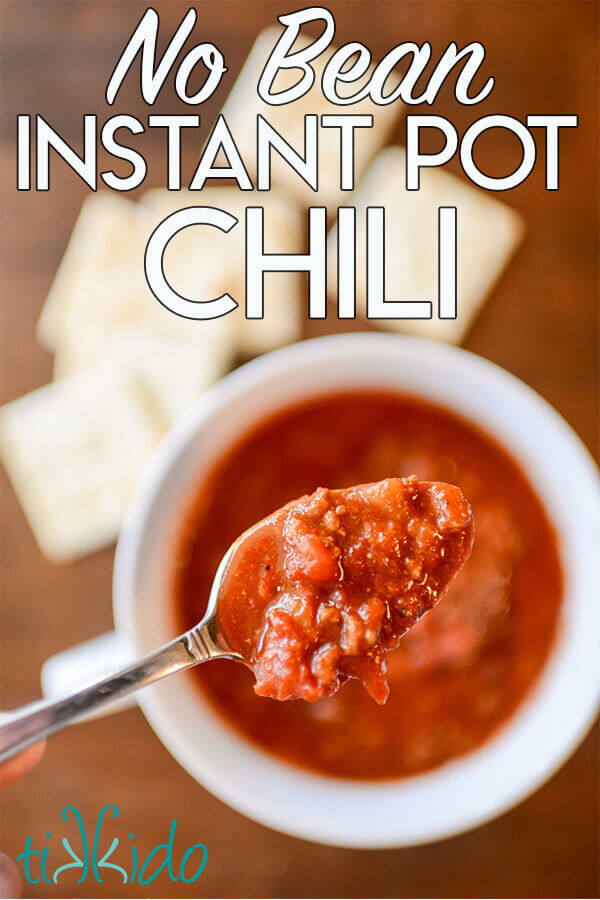 Spoon full of no bean chili made in an Instant Pot pressure cooker, above a white bowl of the chili on a wooden table.