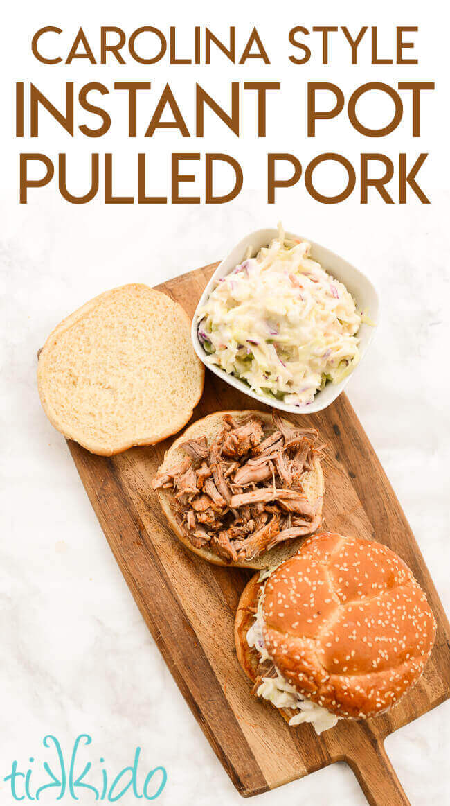 Carolina style pulled pork piled on the base of a hamburger bun, with the top of the hamburger bun beside it, aside a small dish of coleslaw.