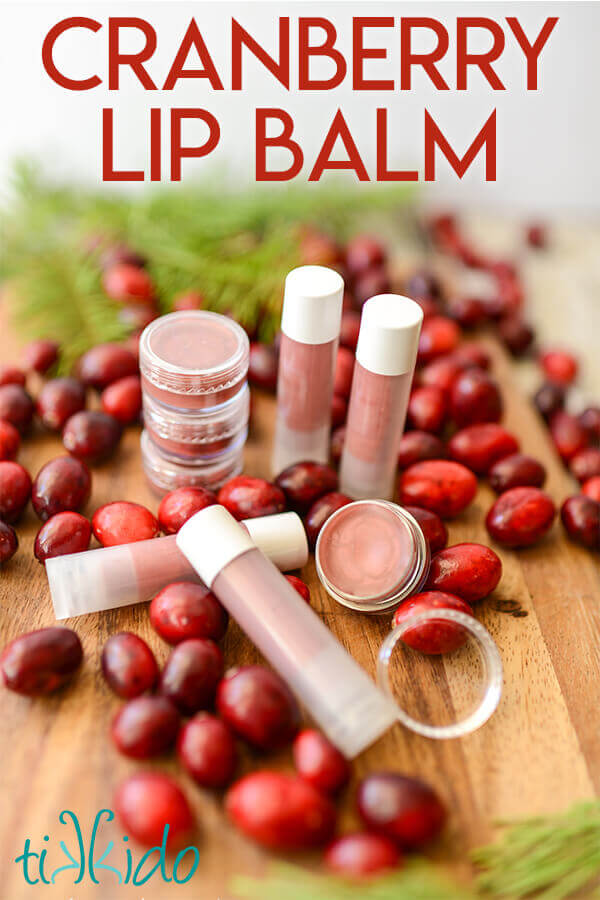Cranberry flavored homemade lip balm surrounded by fresh cranberries.