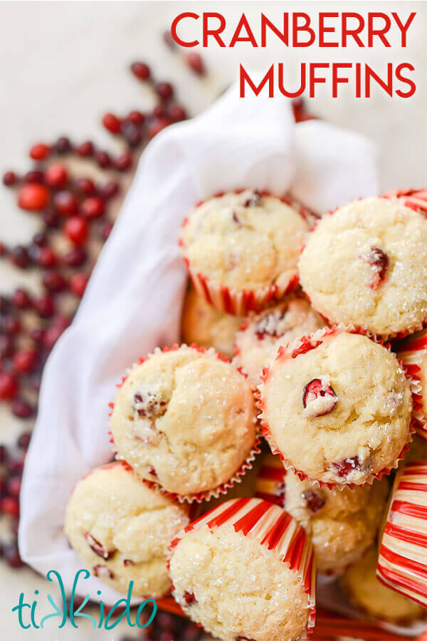 cranberry muffins in a basket, surrounded by fresh cranberries.