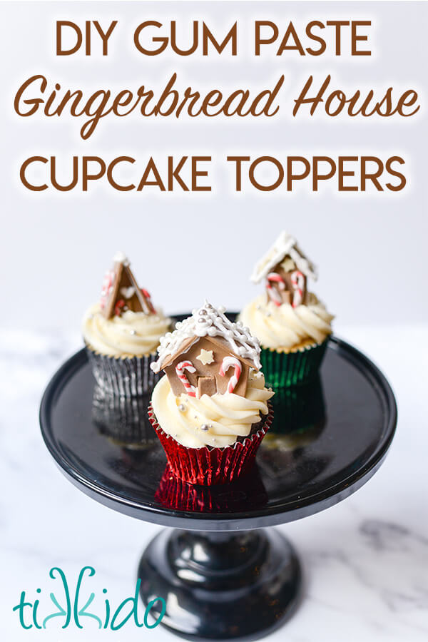 Three Christmas cupcakes topped with miniature gingerbread houses made from gum paste.