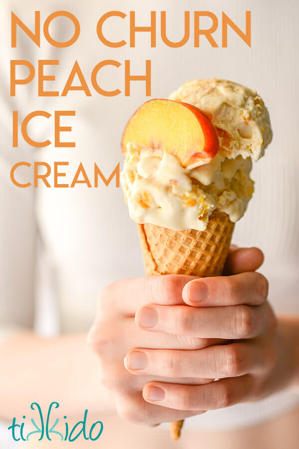 Ice cream cone filled with no churn peach ice cream, held in someone's hands.