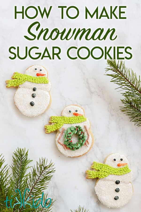 Three snowman sugar cookies  on a white marble background