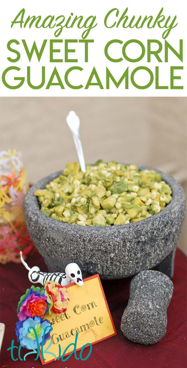 Chunky sweet corn guacamole in a large grey stone mortar and pestle.