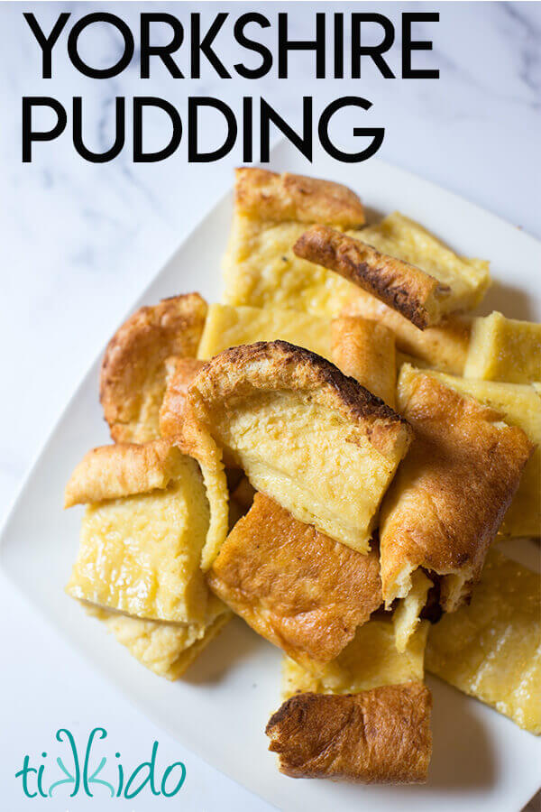 Pieces of Yorkshire pudding on a white plate on a white marble background.