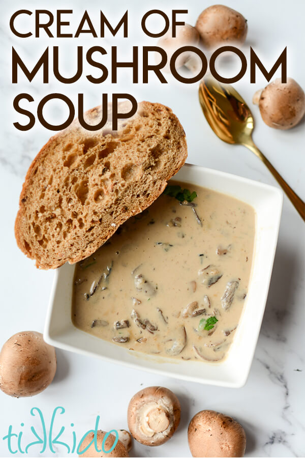 Cream of mushroom soup in a bowl with a piece of crusty bread.