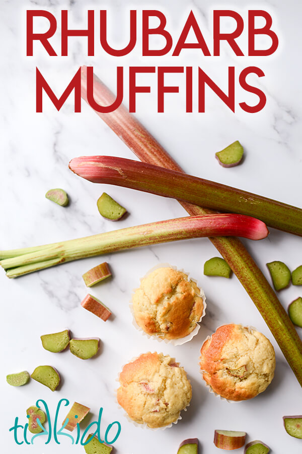 Three rhubarb muffins surrounded by fresh rhubarb, with a text overlay reading "Rhubarb Muffins."