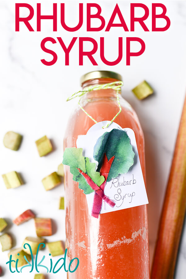 Rhubarb simple syrup in a glass bottle, decorated with a tag that says "Rhubarb Syrup."